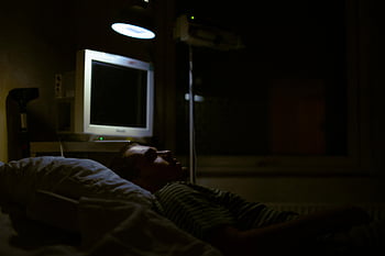 Muž leží na posteli, nemocniční postel, slabé světlo, lékařské vybavení, nemocniční pokoj, pacient v posteli, noční scénu, lékařský monitor, Nastavení zdravotní péče, Obžalovací místnost, trpělivá péče