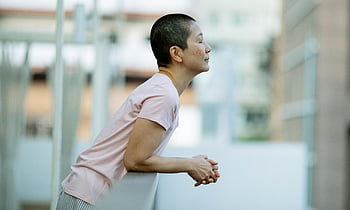 donna asiatica, occhi chiusi, cancro al seno, Donna calma, capelli corti, rilassante, balcone, vista laterale, momento di pace, Consapevolezza della salute, Sopravvissuto al cancro
