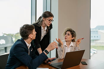 zakelijke bijeenkomst, professionals, modern kantoor, laptop, werkdiscussie, drie mensen, kantooromgeving, zakelijke kleding, samenwerkingswerk, professionele omgeving, Werkplekinteractie
