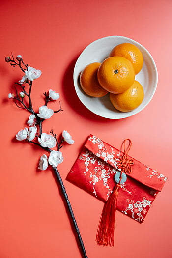 red packet, blooming Sakura, fresh mandarins, Lunar New Year, cherry blossoms, red envelope, flat lay, red background, Chinese New Year, festive decoration, traditional symbols
