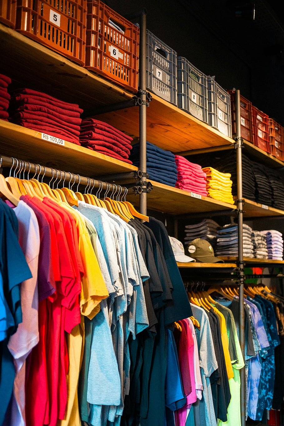 oděvní butik, Vibrující trička, úhledně zobrazený, Organizovaný butik, Barevné košile, maloobchodní displej, módní obchod, obchod s oblečením, Kolekce triček, Nastavení butiku