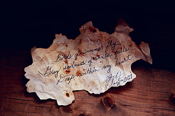 white burnt paper, handwritten poem, vintage atmosphere, moody atmosphere, brown wooden table, stained old paper, vintage style, moody scene, handwritten text, rustic background, antique paper