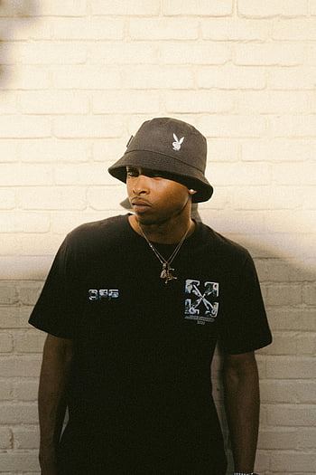ung mand, sort hat, T-shirt, bucket hat, murstens væg, stilfuld, portræt, mode, gadestil, by-, afslappet