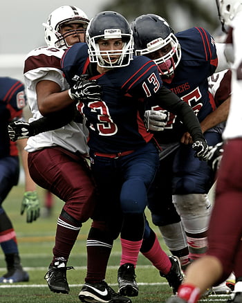 football players, competitive game, dynamic play, athletes in action, sports action, football field, team sports, game intensity, sports competition, football gear, athletic performance