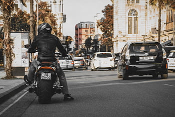 motorcyclist, leather jacket, busy city street, historic buildings, motorcycle, urban riding, city traffic, street scene, motorbike rider, urban motorcyclist, cityscape background