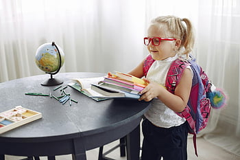 petite fille, devoirs, salon, livres, sac à dos, prêt à étudier, maison, globe, des crayons, table de travail, des lunettes