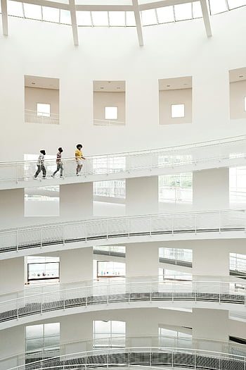 vysoké umělecké muzeum, Muzeum moderního umění, bílá minimalistická architektura, návštěvníci jdoucí, interiér muzea umění, současná architektura, návštěvníků muzea, vnitřní muzejní prostor, minimalistický design, galerie umění, atrium muzea