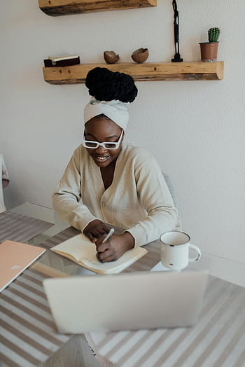donna afroamericana, lavorare da casa, donna felice, Scrivere sul diario, scrivania interna, il computer portatile, tazza di caffè, ufficio a casa, lavoro a distanza, donna sorridente, Apazio di lavoro accogliente