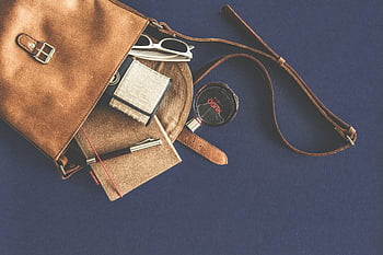 brown leather crossbody bag, white framed sunglasses, luxury accessories, flat lay, leather handbag, wallet, notebook, pen, stylish, accessories, blue background