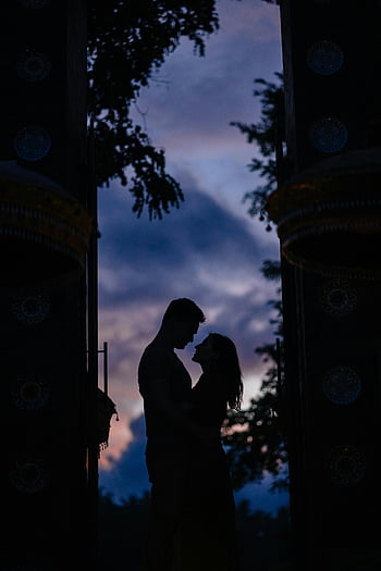 silhouette, hugging couple, arch, darkness, twilight, romance, tranquility, outdoor, serene, embracing, couple