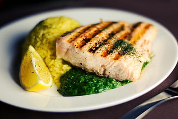 grillattua kalaa, vihreä puuro, viipaloitu sitruuna, valkoinen keraaminen levy, lähikuvaus, elintarvikkeiden esittely, terveellistä ruokaa, gourmet-ruokaa, mereneläviä, sitruuna koristele, vihreä kastike