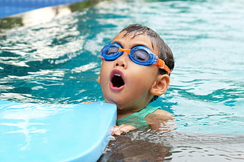 boy in swimming pool, young child swimming, blue goggles, summer fun, pool activity, child in water, swimming lessons, water safety, summer recreation, pool enjoyment, kid swimming