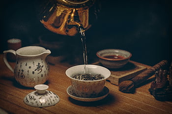 Chinese tea ceremony, porcelain teaware, hot water pour, gold kettle, traditional tea, artistic depiction, tea cup, wooden table, tea leaves, tea ceremony, teapot