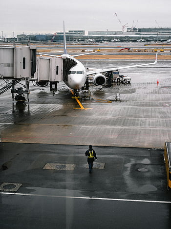 airport, airplane, rainy day, ground crew, walking, airport gate, tarmac, aircraft, jet bridge, aviation, travel