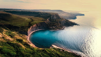 coastal cliffs, turquoise water, lush landscapes, aerial view, green hill, body of water, scenic coastline, natural beauty, ocean view, cliffside scenery, coastal landscape