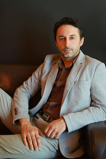 vážný muž, elegantní oblek, sedí na pohovce, sebevědomý podnikatel, neformální oblek, připravený výraz, Vnitřní nastavení, Profesionální oděv, formální oblečení, obchodní profesionál, sedící jednotlivec