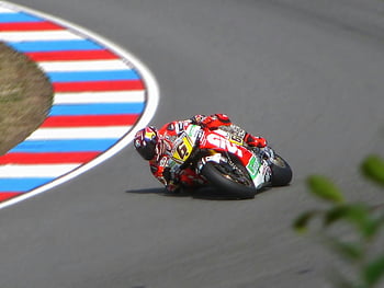 motorcycle racer, red motorcycle suit, red and green sports motorcycle, high-speed track, sharp curve, competition, racing, motorbike, speed, track racing, sports motorcycle