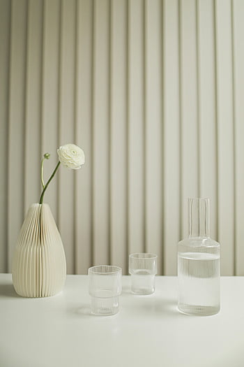 minimalist decor, ceramic vase, glassware, clean table, serene setting, white flower, water glasses, white flower vase, minimalist table setting, modern decor, clean aesthetic