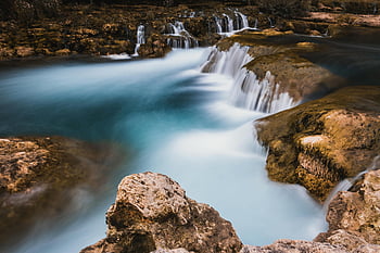 waterfalls, long exposure, small cascading waterfall, rocky terrain, nature's tranquility, natural beauty, serene landscape, flowing water, outdoor scenery, peaceful environment, cascading waterfalls