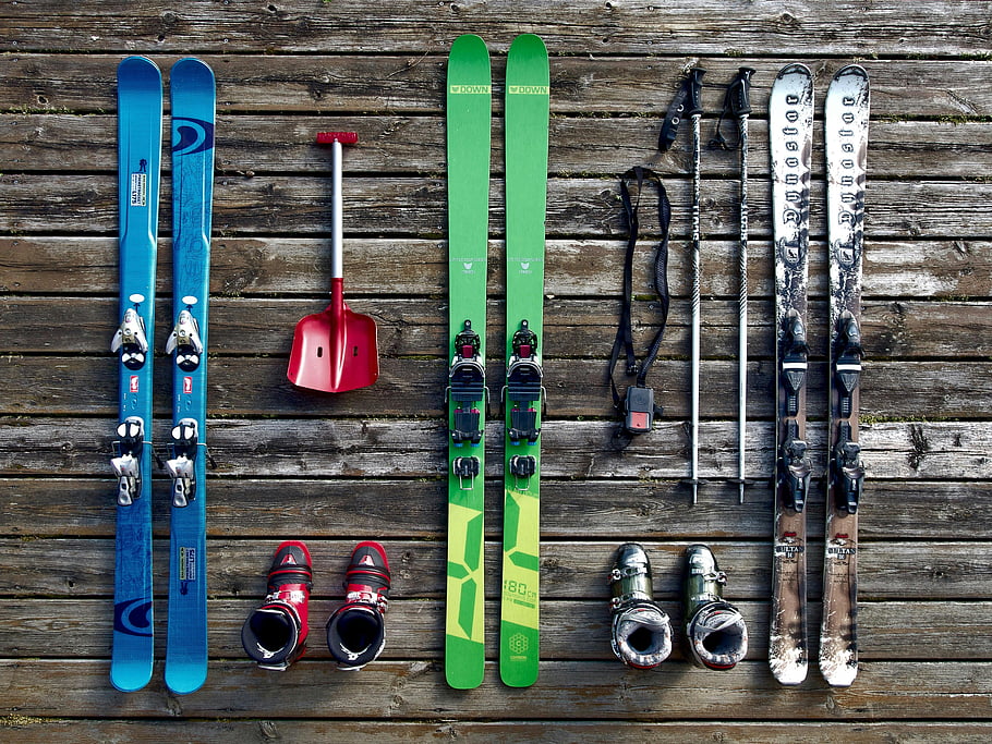 lyžařské vybavení, flatlay, dřevěná paluba, zářivé barvy, prastarý styl, lyže, lyžařské boty, lyžařské hole, lopata, lyžařská kolekce