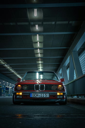 red automobile, low-angle shot, vintage car, dramatic lighting, indoor photography, night scene, red car, BMW, classic car, tunnel shot, automotive photography