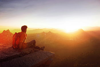 man sitting on edge, sunset view, rocky cliff, Hampi India, breathtaking sunset, man enjoying sunset, outdoor adventure, travel photography, nature landscape, scenic view, backpacker travel