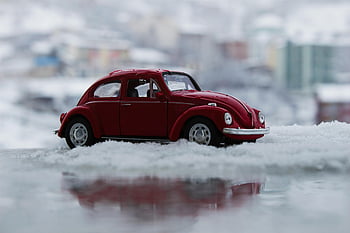 red toy car, snow, vintage VW Beetle, winter scenery, close-up, reflection, outdoor, miniature, red car, toy vehicle, snowy background