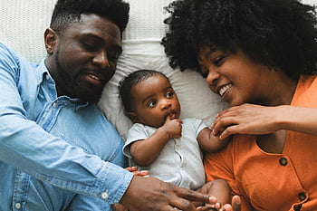 family bonding, smiling parents, baby on bed, love and joy, couple with baby, happy family, parents and child, family moment, bed bonding, family love, baby bonding