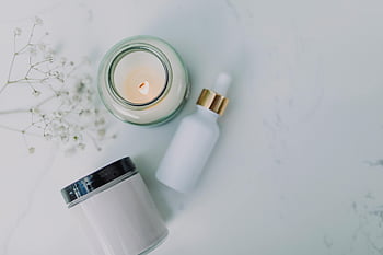 spa essentials, candle, dropper bottle, jar, white marble, relaxation, self care, aromatherapy, essential oils, minimalist, still life