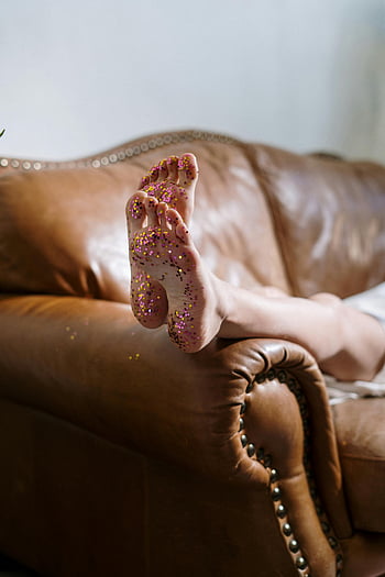 picioare cu sclipici, canapea de piele, Setare elegantă, Picioare apropiate, picioare sclipitoare, canapea maro, setare confortabilă, fotografierea în interior, Stil casual, decoratiune interioara, atmosfera relaxata