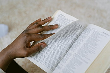 Holy Bible, person reading, scripture, thoughtful hand, turning pages, religious text, open book, spiritual reading, faith study, religious study, Bible study