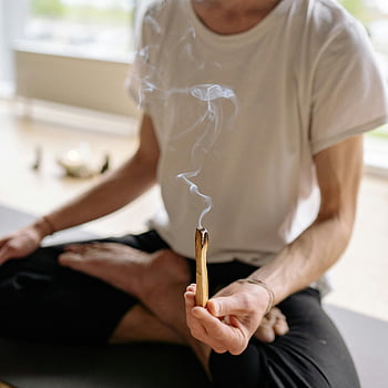 palo santo, Burning Palo Santo, duchovní wellness, relaxace, detailní fotografie, osoba drží, svatý dřevo, rozjímání, kouř, aromaterapie, Wellness praxe