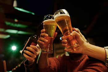 friends toasting, beer glasses, lively bar, close-up photo, social gathering, drinking beer, celebration moment, friendly atmosphere, nightlife scene, group celebration, beer toast