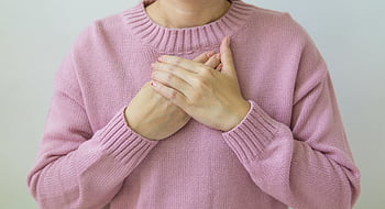 donna, Mano sul petto, maglione rosa tenue, cura, benessere, tocco gentile, Salute, cura di sé, comfort, benessere emotivo, consapevolezza