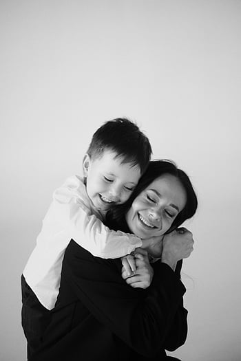 madre e hijo, madre sonriente, Hijo abrazando, retrato en blanco y negro, Madre alegre, abrazo, momento familiar, maternidad, familia feliz, Conexión emocional, fotografía en blanco y negro