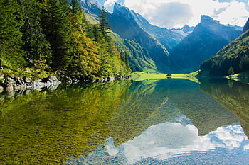 Fotografia riflettente, montagne verdi, Lago di montagna sereno, Riflessioni chiare, vegetazione lussureggiante, appassionati di natura, scenario di montagna, acque calme, paesaggio naturale, bellezza all'aperto, ambiente tranquillo