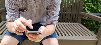 muž, hnědá lavička, chytrý telefon, venkovní nastavení, neformální, Hnědá a bílá kostkovaná košile, během dne, sedící, pomocí telefonu, Neformální outfit, venkovní aktivita
