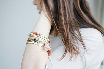 woman, white crew-neck top, elegant bracelets, vibrant accessory fashion, arm accessories, colorful jewelry, bohemian style, fashion accessory, bracelet set, tassel bracelet, arm jewelry
