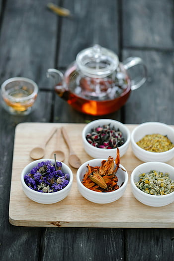 getrocknete Kräuter, Keramikschalen, Tee brauen, Glasteekanne, Holzbrett, mehrfarbige Kräuter, getrocknete Blumen, Teezubereitung, Kräutertee, Holzlöffel, Tee Set