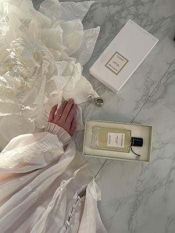 hand, metal rings, perfume bottle, box, flat lay, bridal scene, flowing fabric, romantic touch, marble surface, elegant setup, wedding accessories
