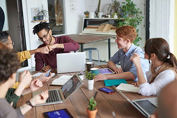 Fauststoß, junge Profis, modernes Büro, Brainstorming, Verschiedene Gruppen, Tabelle, Laptops, Zusammenarbeit, Büroumgebung, Zusammenspiel, Treffen