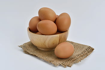 brown eggs, wooden bowl, beige knit textile, burlap fabric, high resolution, food-themed content, brown eggs in bowl, wooden bowl on fabric, rustic food photography, natural food presentation, egg photography