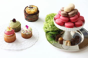 desserts op tafels, macarons, cupcakes, levendige weergave, dessertpresentaties, staan, kleurrijke desserts, zoete lekkernijen, gebakjes, snoepgoed, bakkerijartikelen