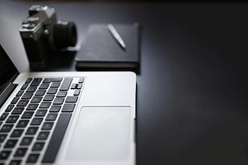 szürkeárnyalatos fényképezés, laptop, könyv, kamera, modern munkaterület, karcsú fekete íróasztal, jegyzetfüzet, toll, íróasztal beállítás, irodai felszerelés, munkaterület -szervezet