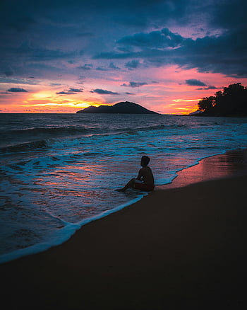 sunset beach, tranquil scene, ocean waves, solitary silhouette, beach sunset, red sky, blue ocean, peaceful moment, coastal view, evening beach, sunset silhouette