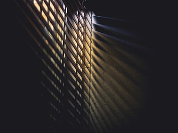 low light photography, brown window blinds, dramatic light, shadows, moody atmosphere, indoor lighting, window blinds, light and shadows, interior design, architectural photography, natural light