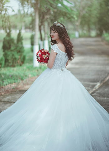 Žena v bílých svatebních šatech, červená kytice, krásná nevěsta, elegantní bílé svatební šaty, venkovní svatba, svatební kytice, svatební fotografie, Nevěsta venku, svatební šaty, červené květy, svatební portrét