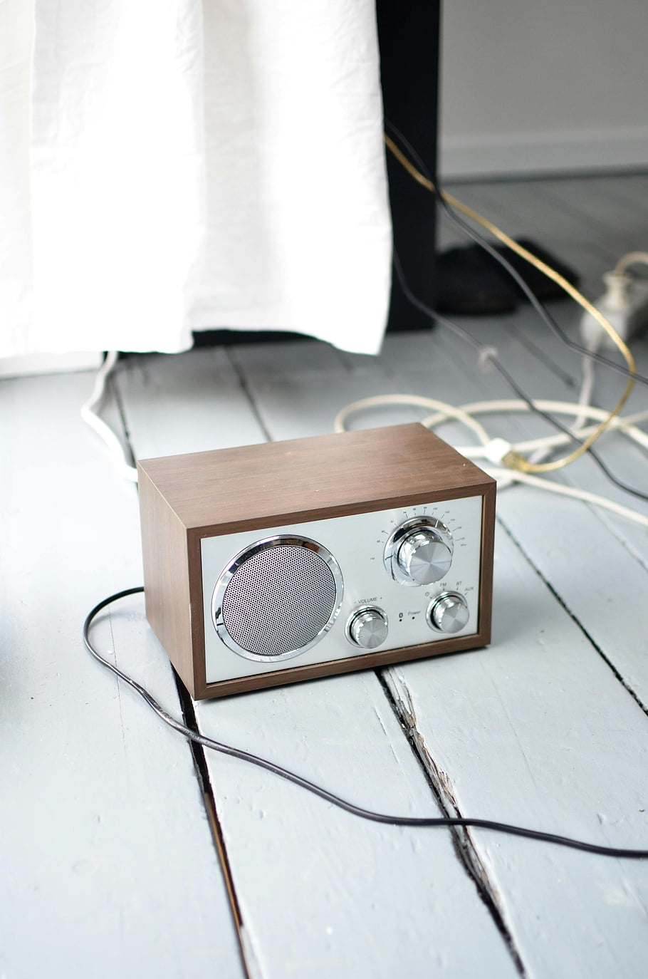 retro styled radio, wooden floor, classic wooden radio, light painted floor, indoor setting, wires around, vintage radio, modern design, audio equipment, home decor, minimalist style