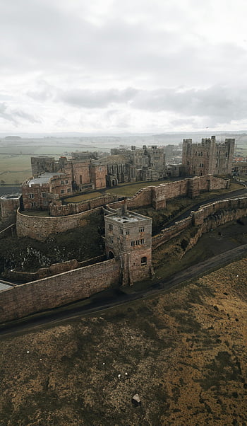 bamburgh slot, Northumberland, uk, middelalderlig charme, luftfoto, skyet dag, historisk sted, slot ruiner, Nordengland, naturskønne landskab, middelalderlig arkitektur