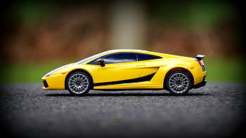 yellow die-cast toy, sports car model, close-up toy car, yellow toy car, asphalt background, blurred background, toy coupe, die-cast toy, sports car toy, yellow sports car, toy car photography